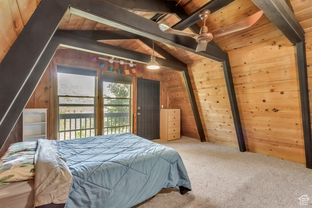 Carpeted bedroom with wooden walls and wood ceiling