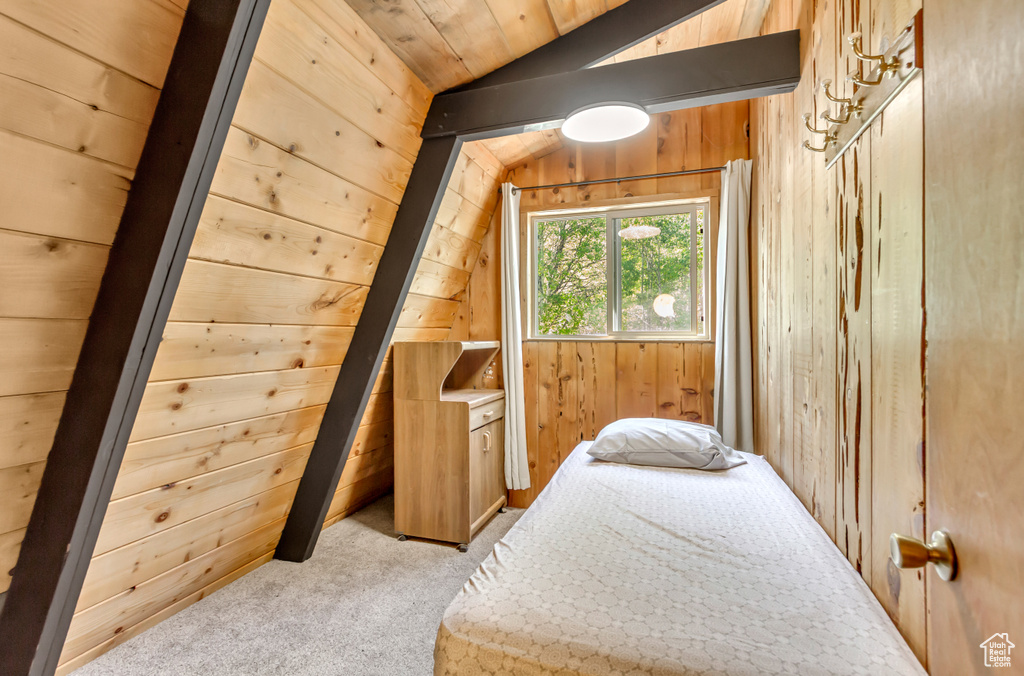 Carpeted bedroom with vaulted ceiling and wooden walls