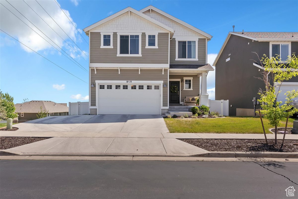 View of front of home with concrete driveway and a garage