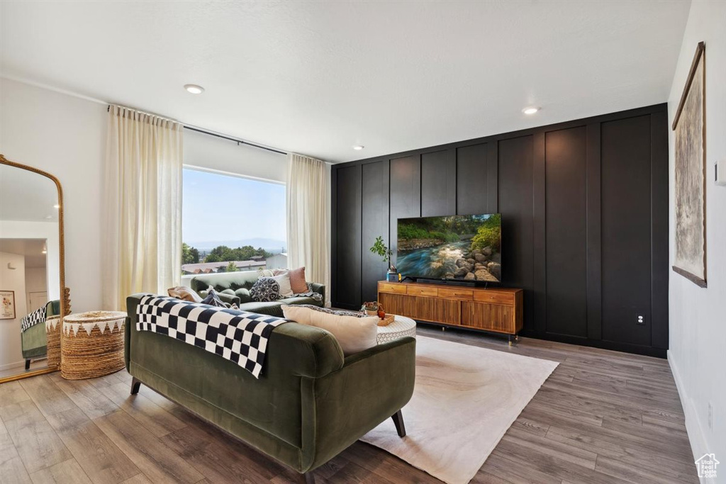 Living room with light wood-type flooring and recessed lighting