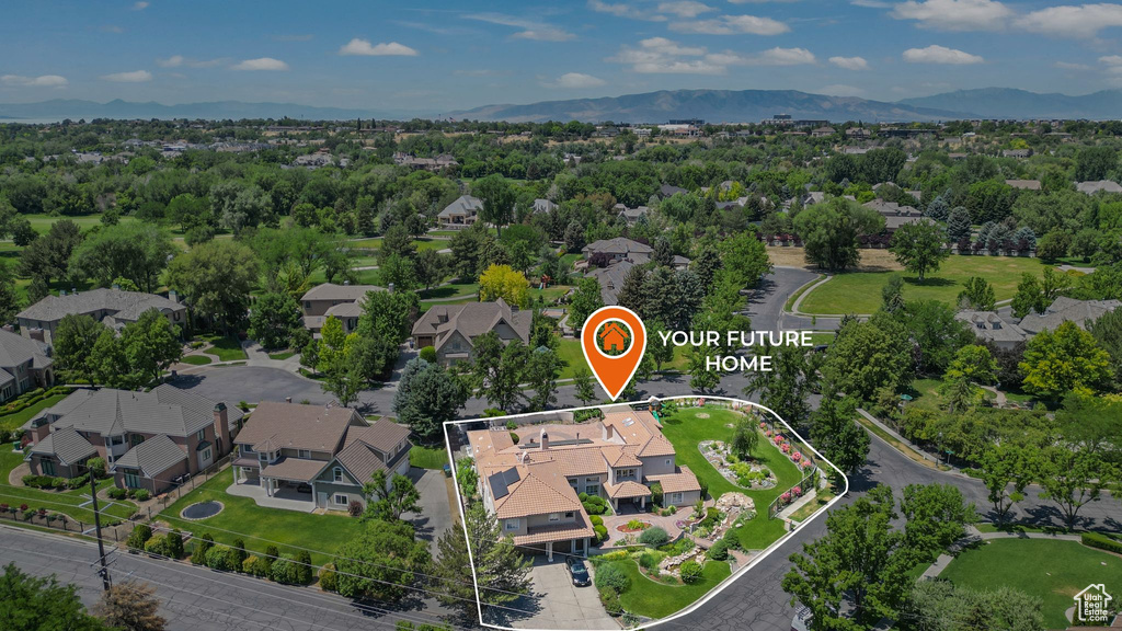 Aerial perspective of suburban area with property boundaries highlighted and a mountainous background