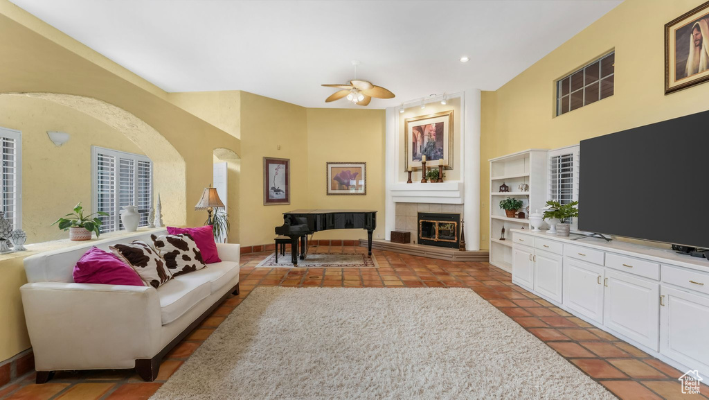 Tiled living area featuring ceiling fan, a fireplace, and recessed lighting
