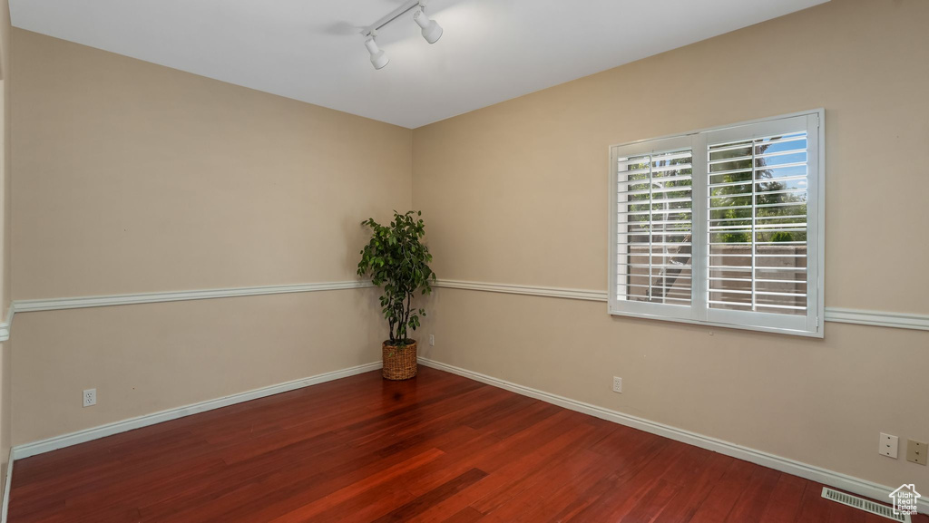 Unfurnished room featuring wood finished floors and track lighting