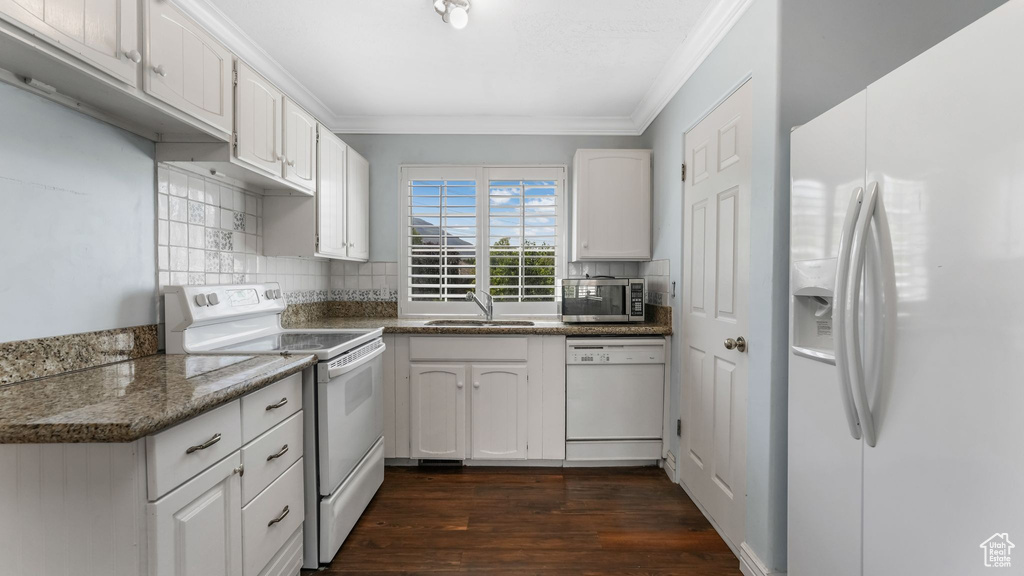 Kitchen featuring white appliances, ornamental molding, white cabinets, decorative backsplash, and dark wood-type flooring
