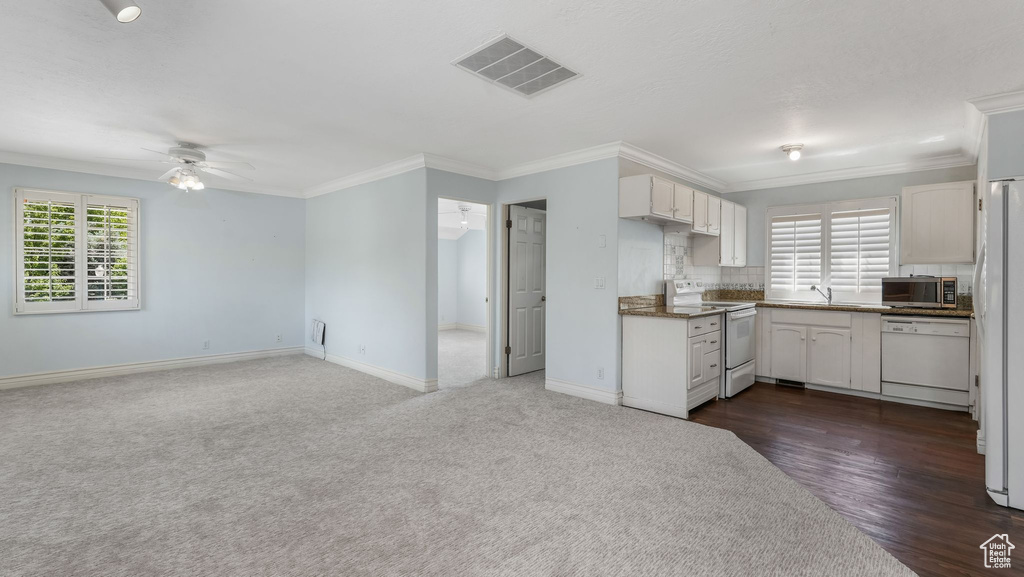 Kitchen featuring white appliances, a ceiling fan, crown molding, white cabinets, and open floor plan