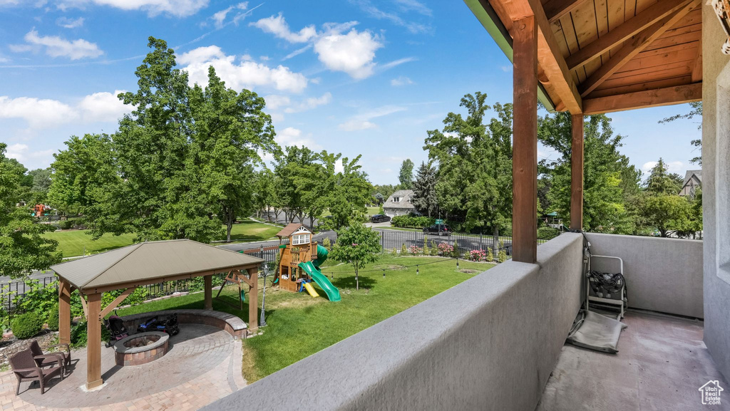 Balcony featuring an outdoor fire pit and view of wooded area