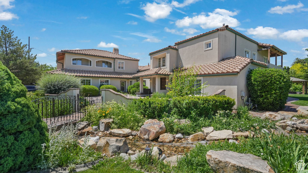 View of front of house featuring stucco siding and a tiled roof