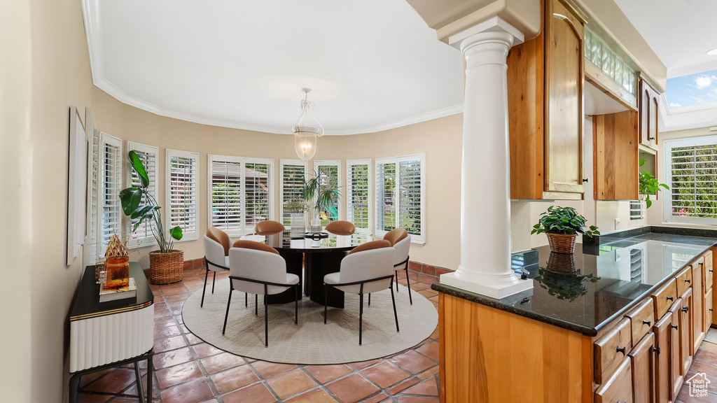 Dining area with ornate columns, ornamental molding, and light tile patterned floors