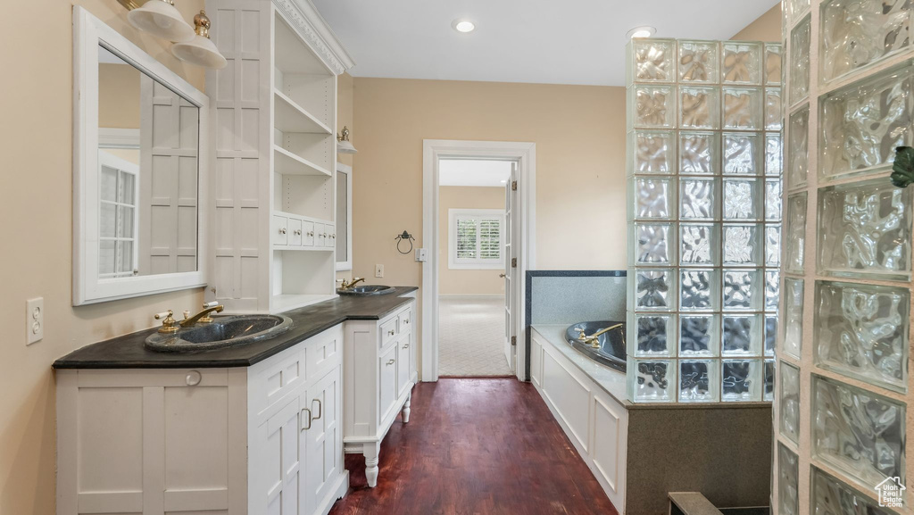 Full bathroom with vanity, wood finished floors, and a garden tub