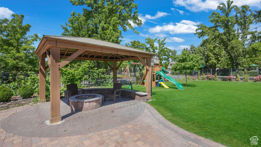 View of patio with an outdoor fire pit and a gazebo