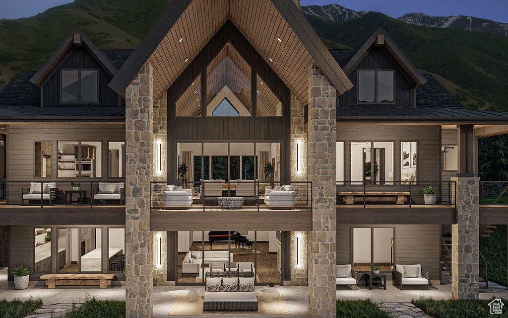 Back of property featuring an outdoor living space, a mountain view, a patio, a standing seam roof, and board and batten siding