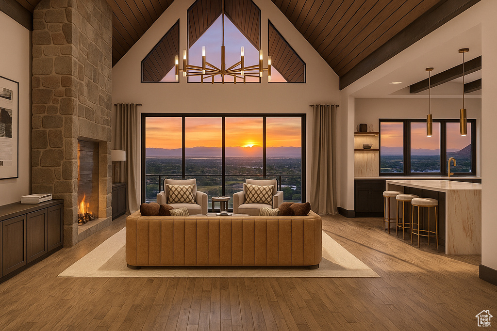 Living room featuring a fireplace, wood ceiling, a chandelier, light wood-type flooring, and high vaulted ceiling