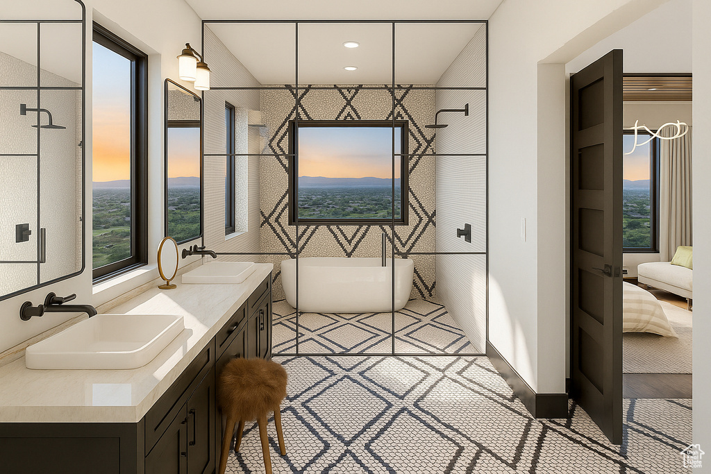 Ensuite bathroom featuring a soaking tub, double vanity, and plenty of natural light