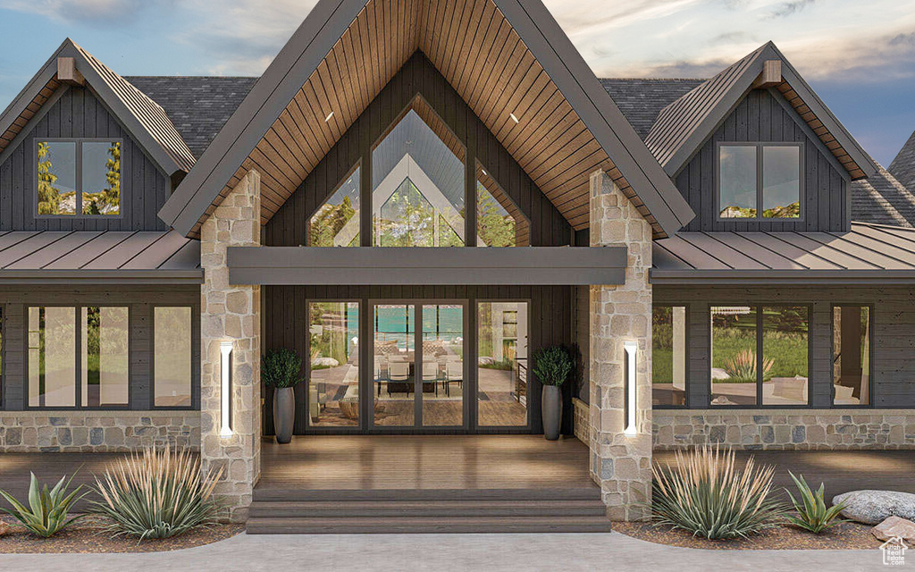 Entrance to property featuring a standing seam roof, stone siding, and a metal roof