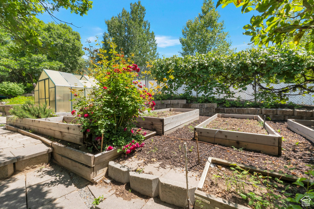 View of yard featuring a vegetable garden, an exterior structure, and an outdoor structure