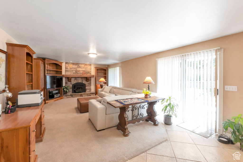 Living room with built in features, light tile patterned floors, and a fireplace