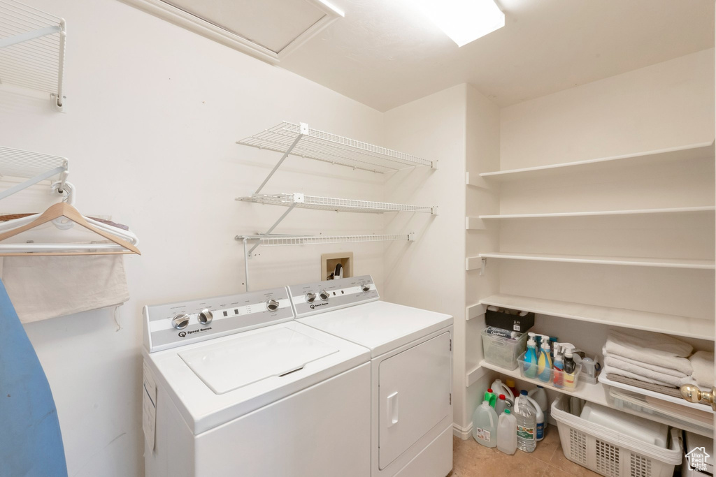 Laundry area featuring washing machine and dryer and light tile patterned floors