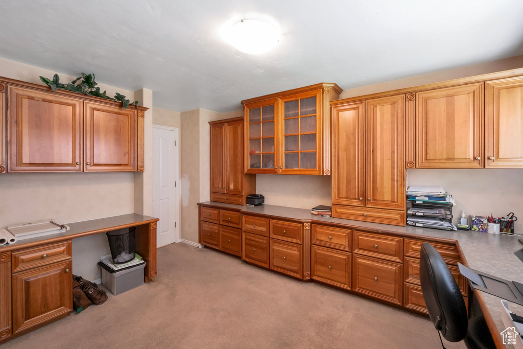 Home office with built in study area and light colored carpet