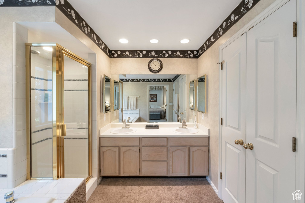 Bathroom with a shower stall, double vanity, and recessed lighting