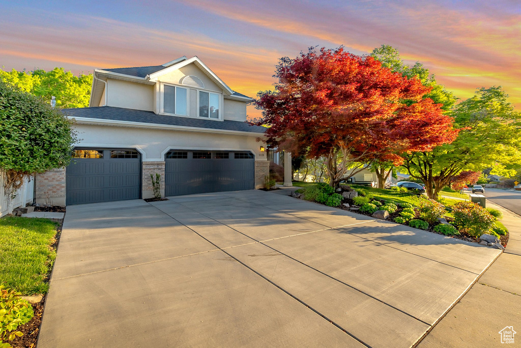 View of front of property with an attached garage, stucco siding, and driveway