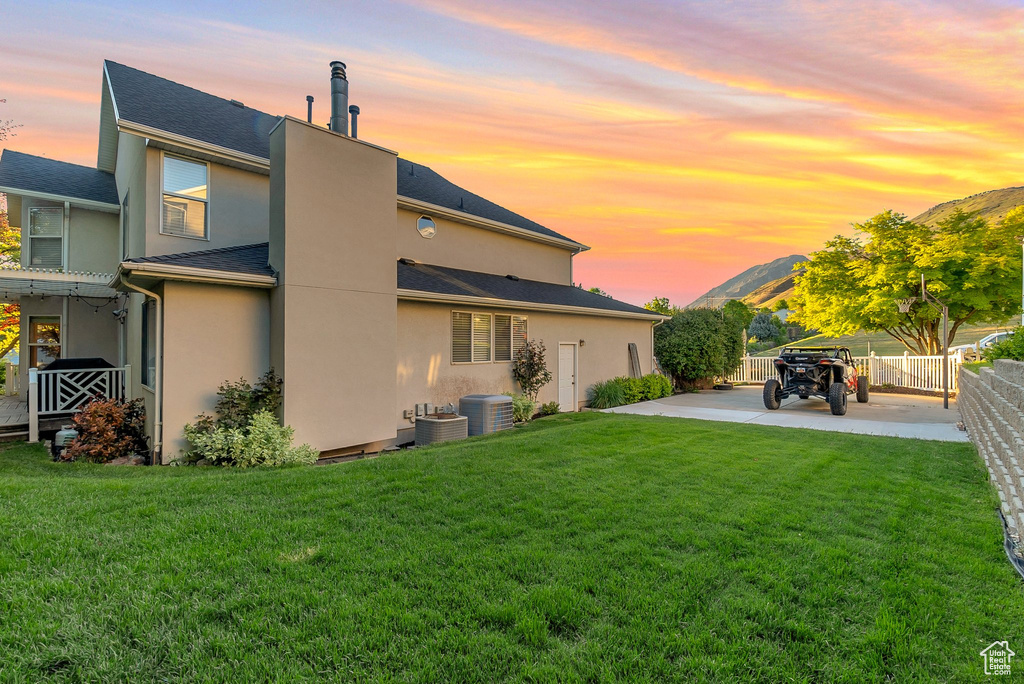 Back of property at dusk with stucco siding and a mountain view