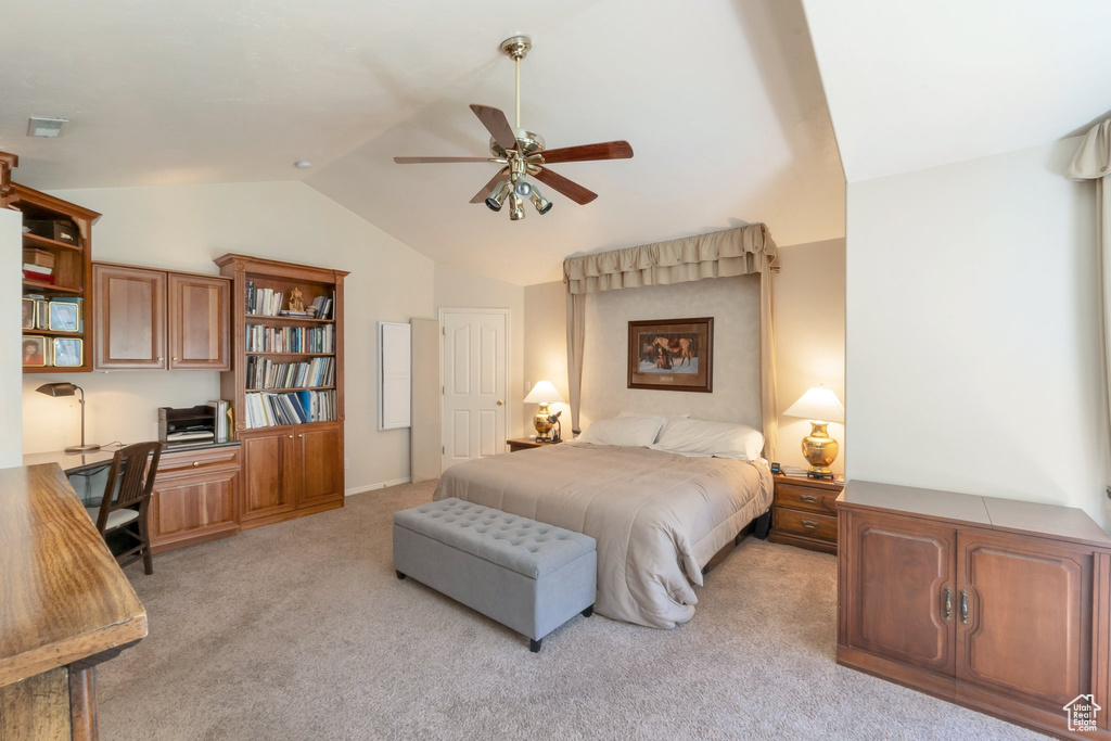Bedroom with light carpet, lofted ceiling, built in desk, and ceiling fan