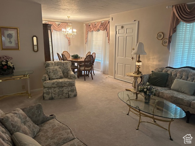 Carpeted living area with a chandelier and a textured ceiling