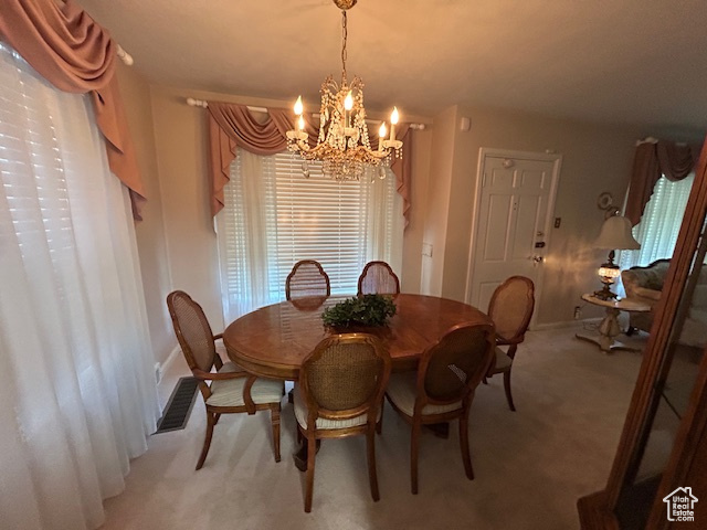 Dining area featuring a chandelier and light colored carpet