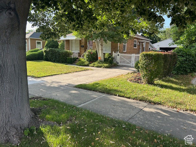 Obstructed view of property with brick siding and a gate