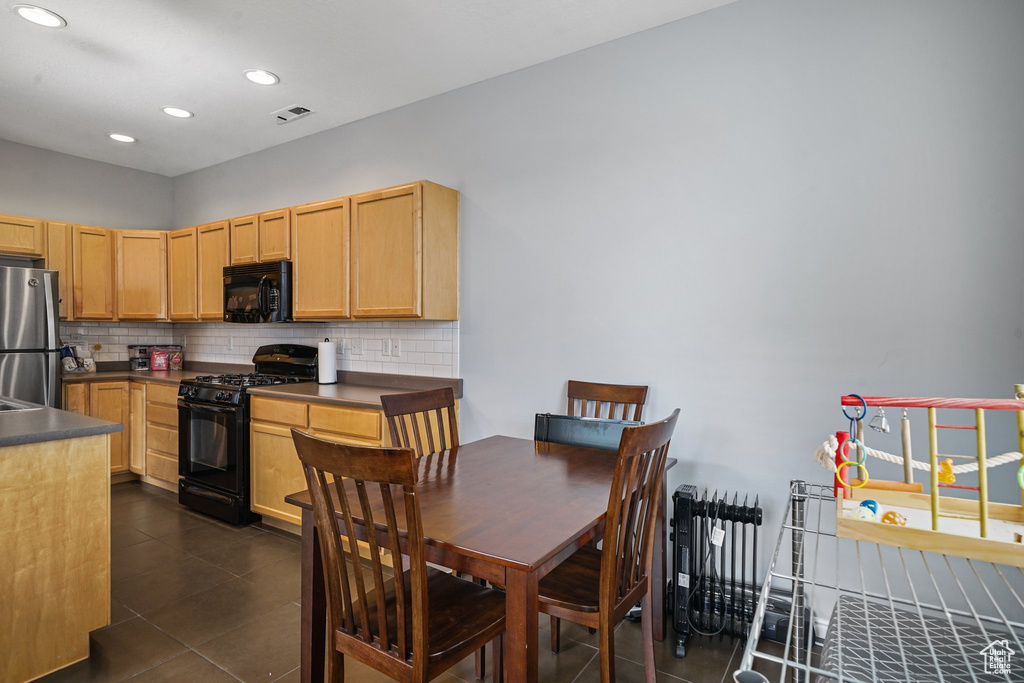 Kitchen featuring black appliances, dark countertops, backsplash, and recessed lighting