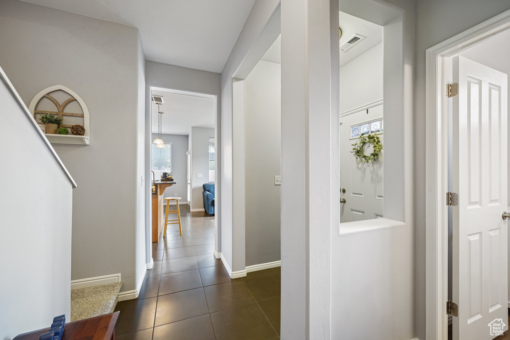Corridor with healthy amount of natural light and dark tile patterned floors