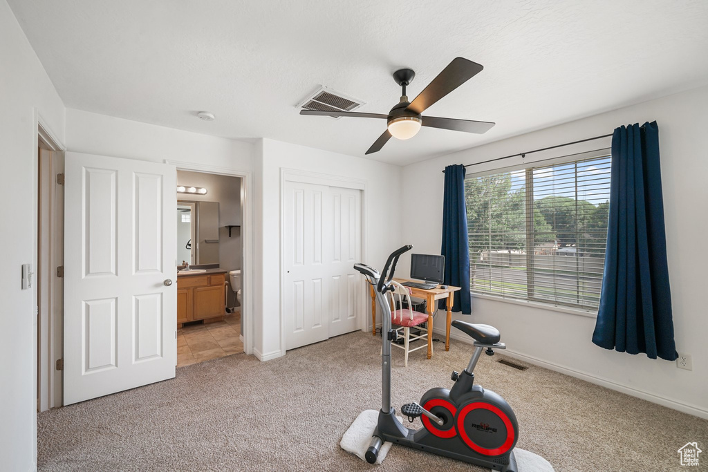 Workout room with light carpet and ceiling fan