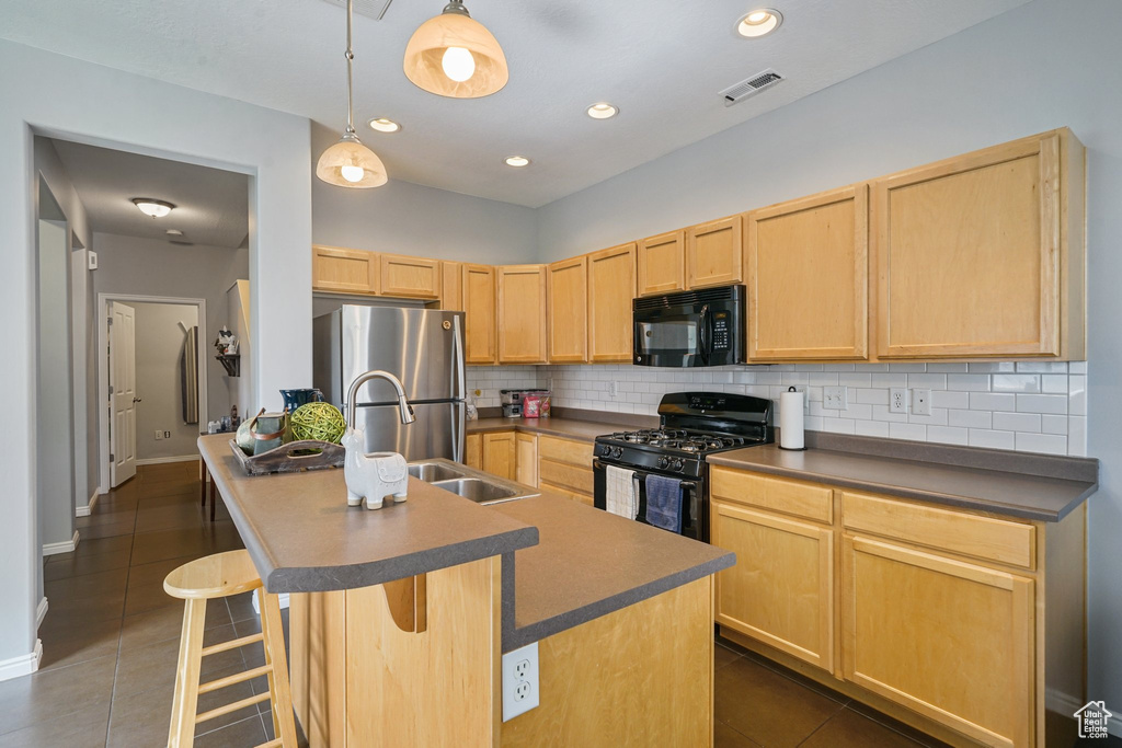 Kitchen featuring black appliances, light brown cabinetry, tasteful backsplash, dark tile patterned floors, and recessed lighting
