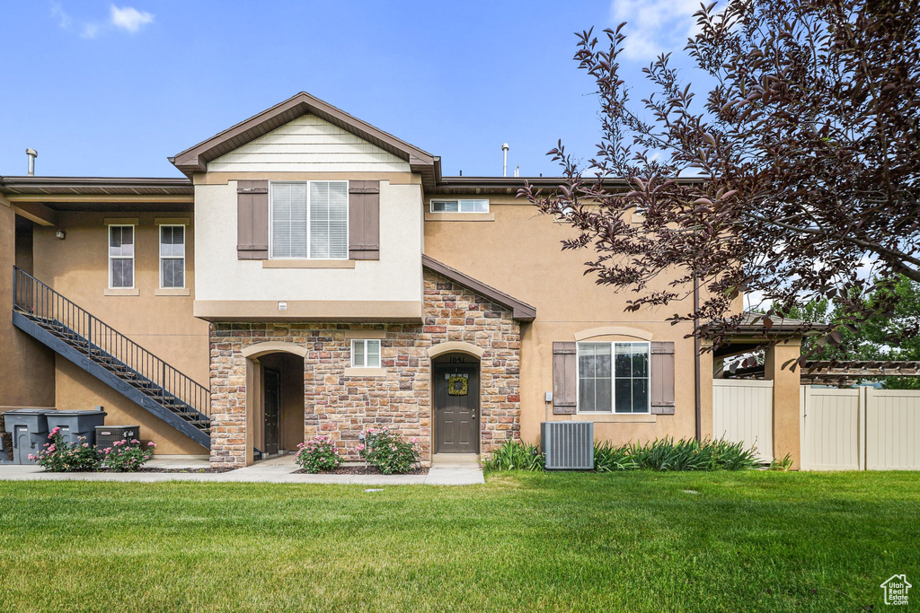 View of property with stucco siding and stone siding