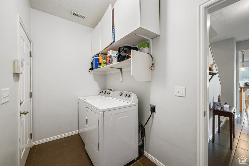 Laundry area with washing machine and clothes dryer and dark tile patterned floors