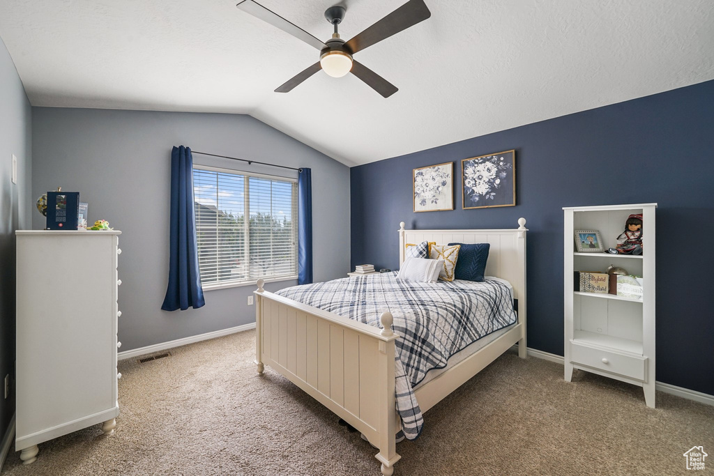 Bedroom featuring carpet floors, lofted ceiling, and a ceiling fan