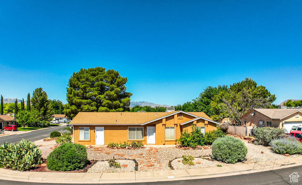 Ranch-style home with a mountain view and stucco siding