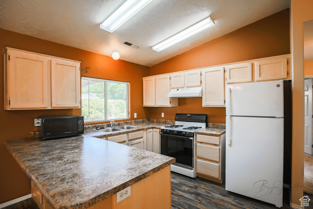 Kitchen with freestanding refrigerator, range with gas cooktop, under cabinet range hood, black microwave, and vaulted ceiling