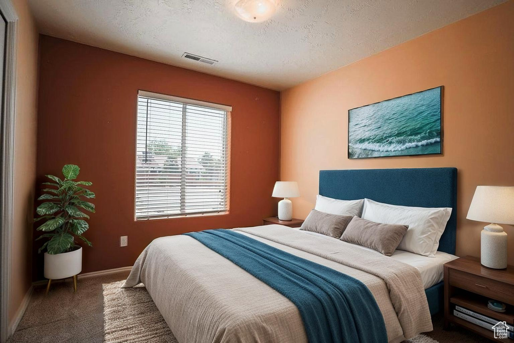 Carpeted bedroom with baseboards and a textured ceiling