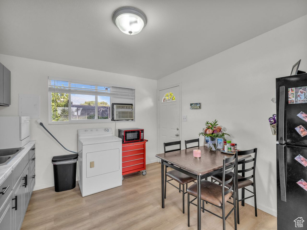 Dining room with washer / dryer and light wood-style floors