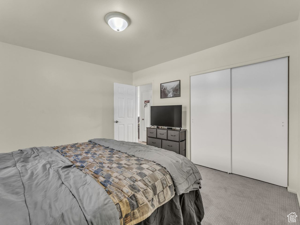 Bedroom featuring light carpet and a closet