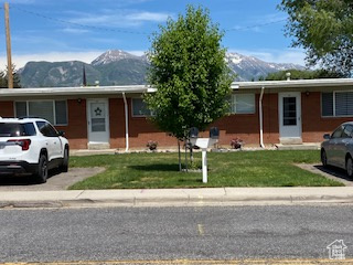 Single story home with a mountain view and a front yard