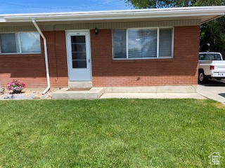 View of front of property with a front yard and brick siding