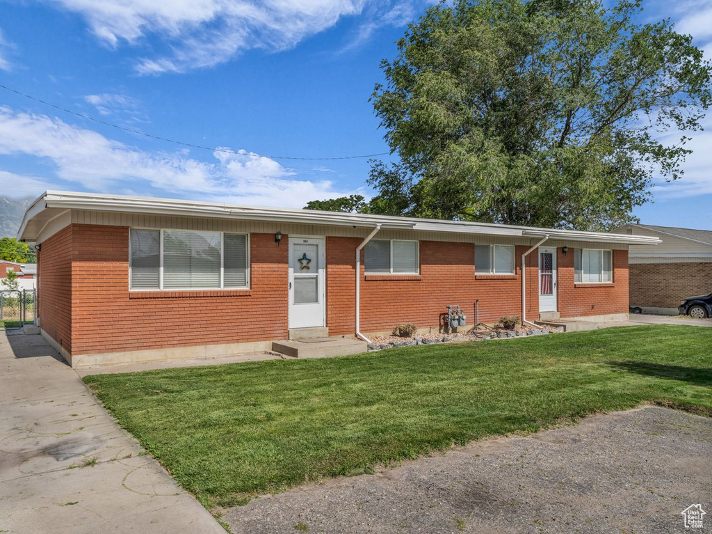 Ranch-style house with entry steps, brick siding, and a front lawn