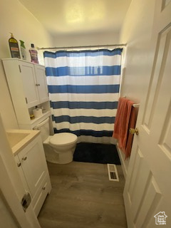 Full bath featuring vanity, curtained shower, and wood finished floors
