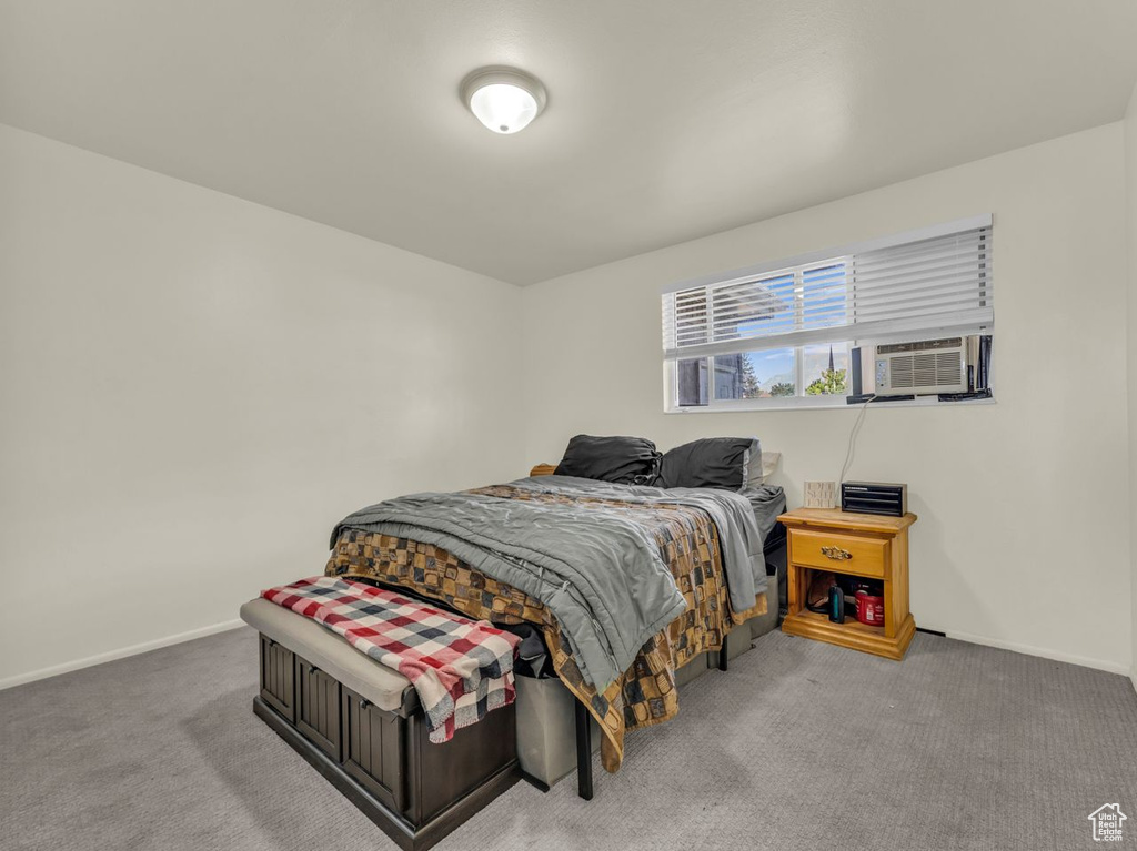 Carpeted bedroom featuring baseboards and cooling unit