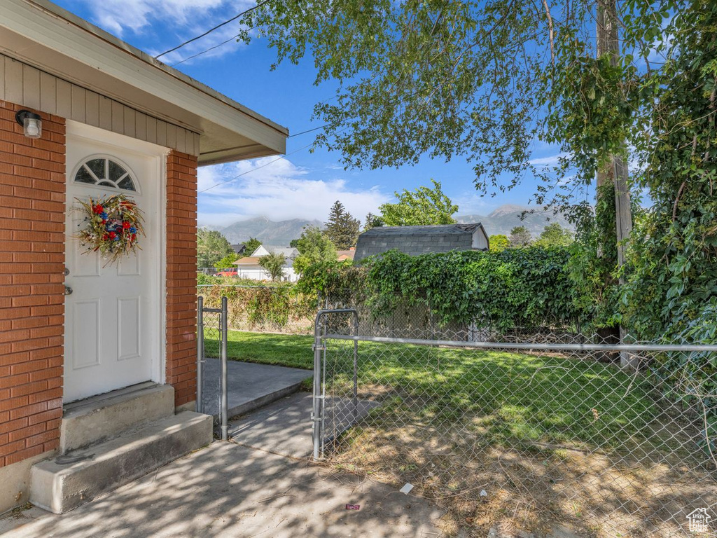 Doorway to property featuring brick siding, a mountain view, and a gate