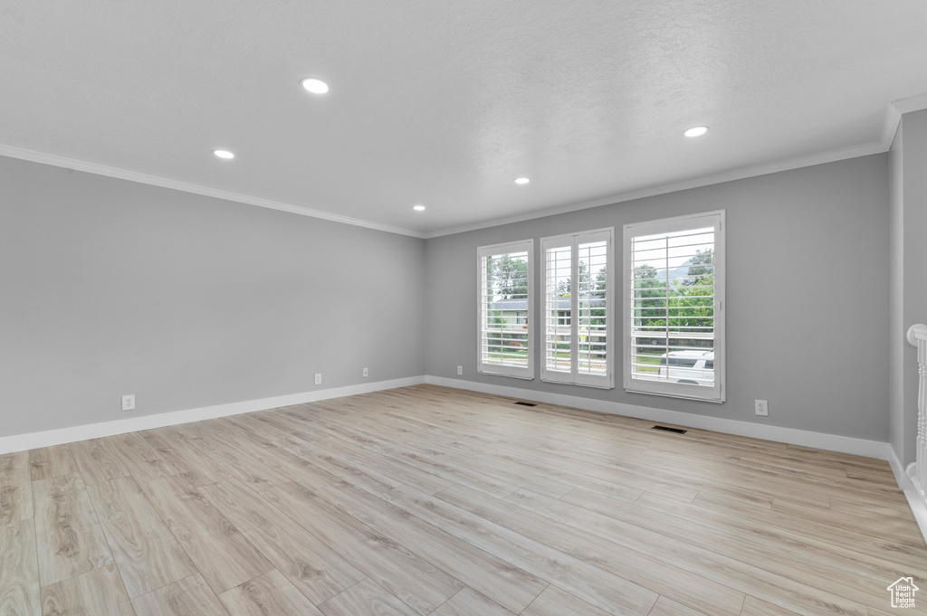 Spare room featuring crown molding, recessed lighting, and light wood-style flooring