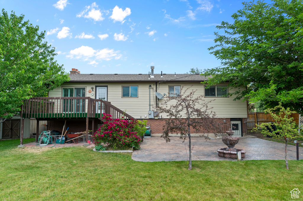 Rear view of house featuring a patio, a wooden deck, stairs, and a chimney