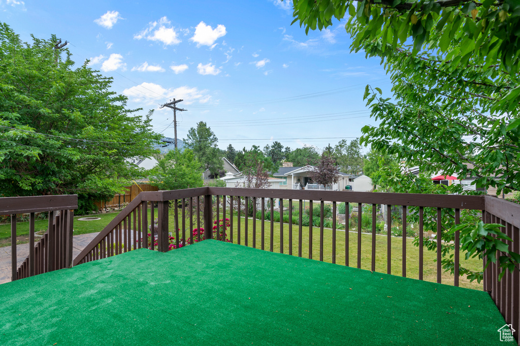 Wooden terrace with a fenced backyard